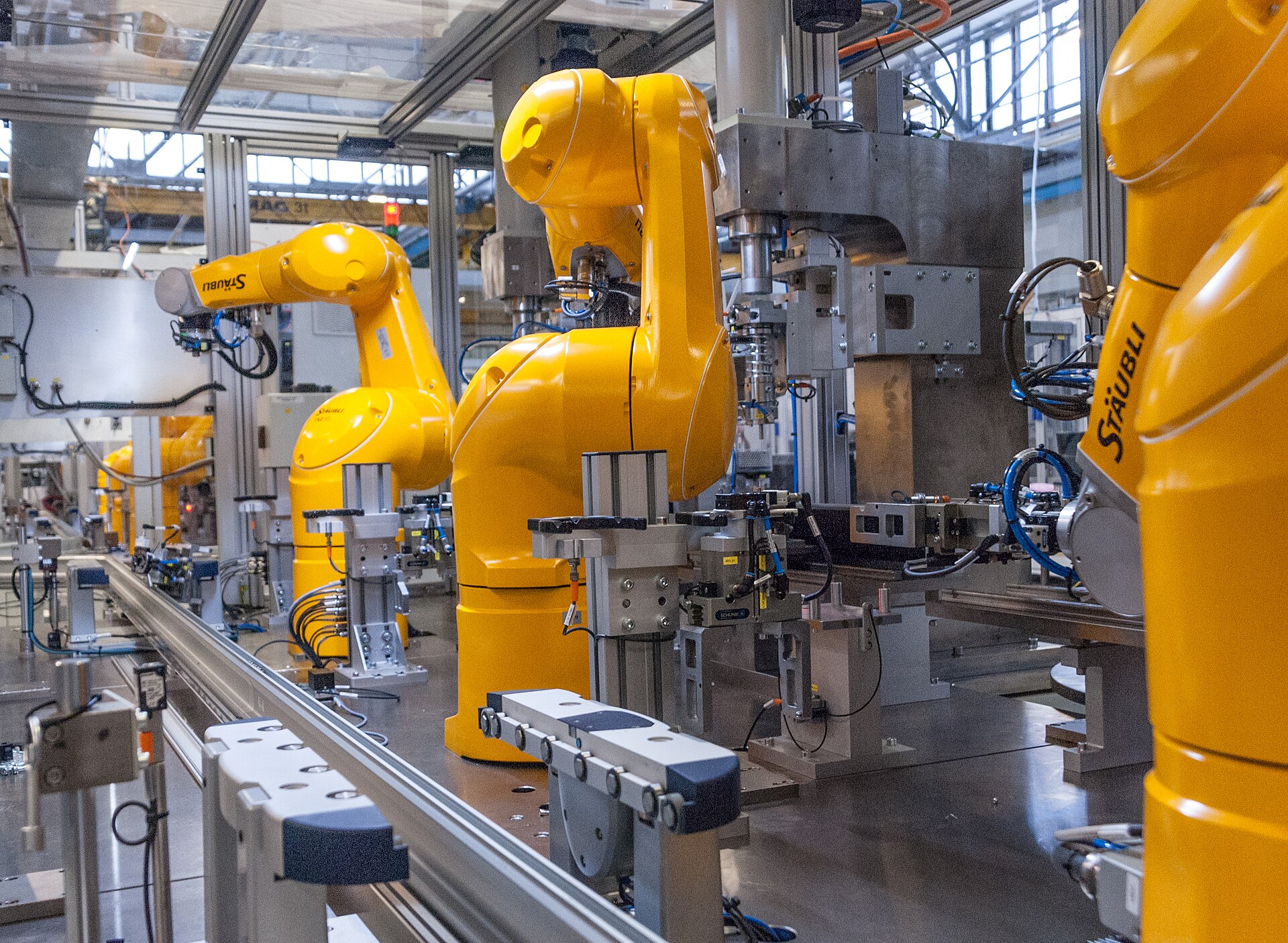 Line of industrial robot arms on an assembly cell